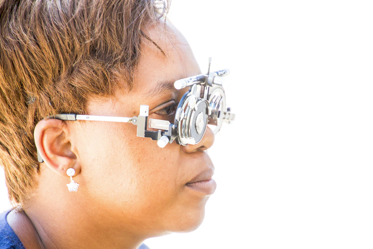 A woman looking into an eye measuring device during a contact lens fitting