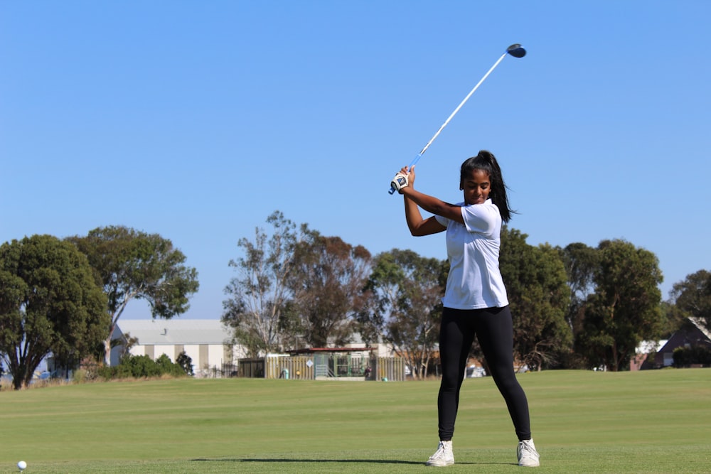 woman holding golf club during daytime