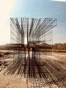 Construction crew carefully installing steel rebar on a residential foundation site under overcast skies.