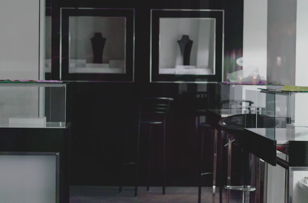A sleek, dark exhibition booth glowing with subtle orange ambient lighting and geometric glass overlays.