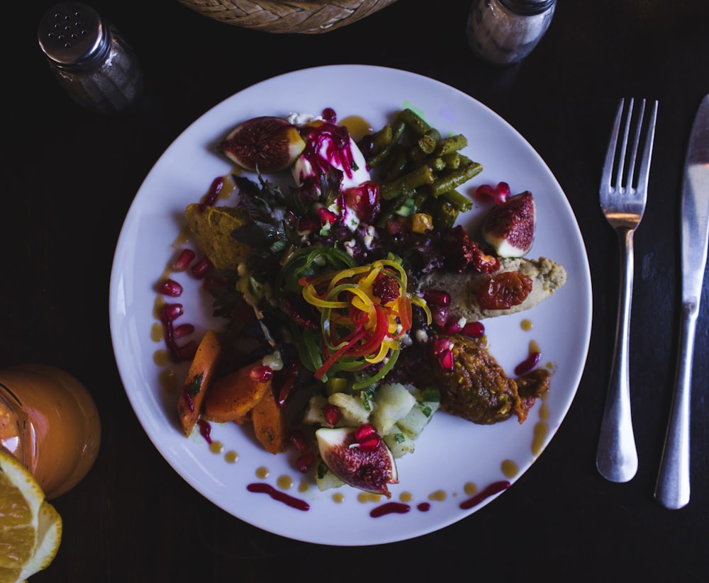 cooked food on white ceramic plate beside fork