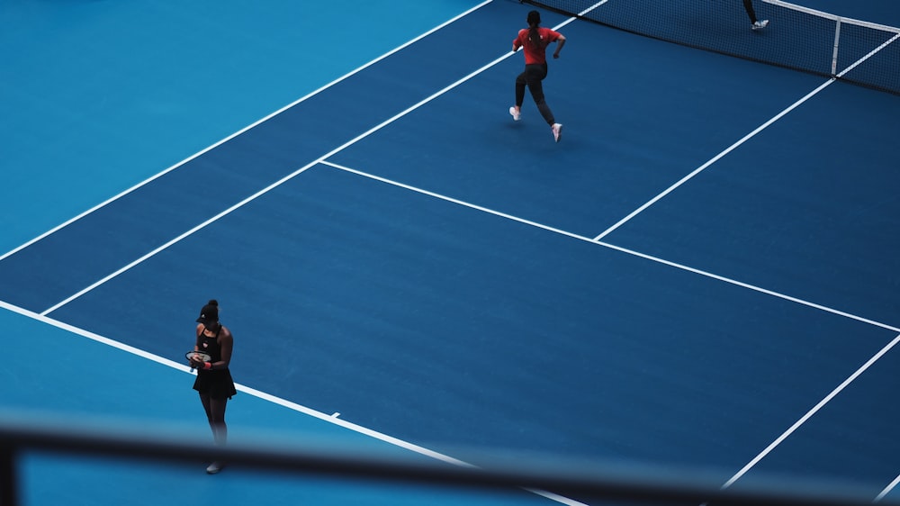 duas pessoas jogando tênis durante o dia