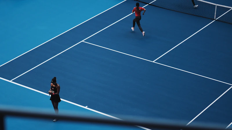 Dos jugadores peloteando en una pista de tenis — clases en pareja