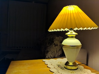 A stylish table lamp casting warm light over a cushion-covered sofa.