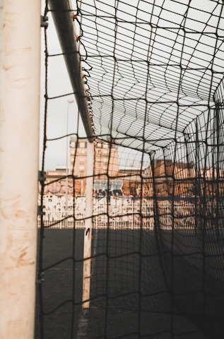 Close-up of a soccer ball hitting the net for a goal in a packed arena.