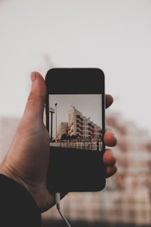Close-up of hands holding a smartphone displaying a property listing on the Buyer portal.
