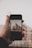 A close-up of a hand holding a smartphone displaying real estate listings.
