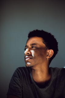 Actress reflecting quietly between takes, sunlight casting soft shadows on her face.