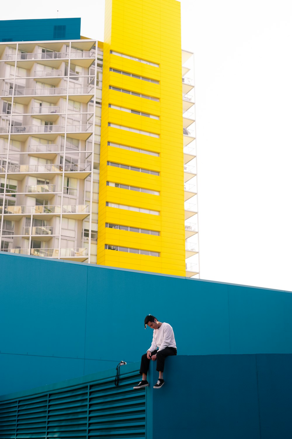 man sitting blue painted building