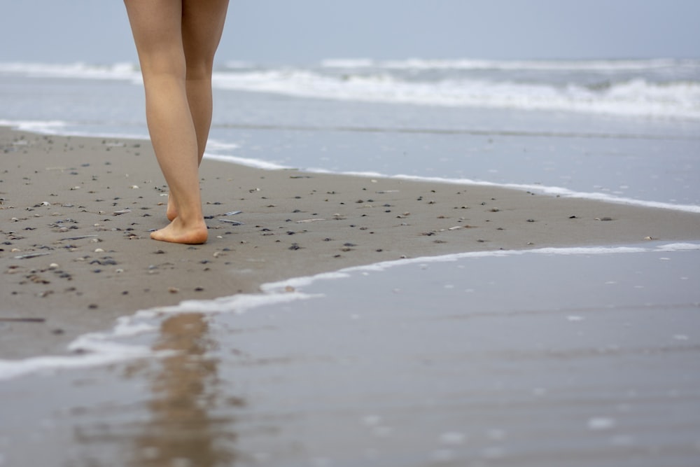 person's leg walking on beach