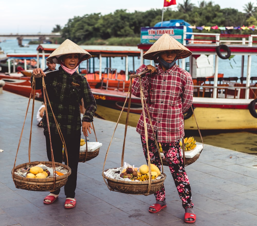 two person carrying baskets