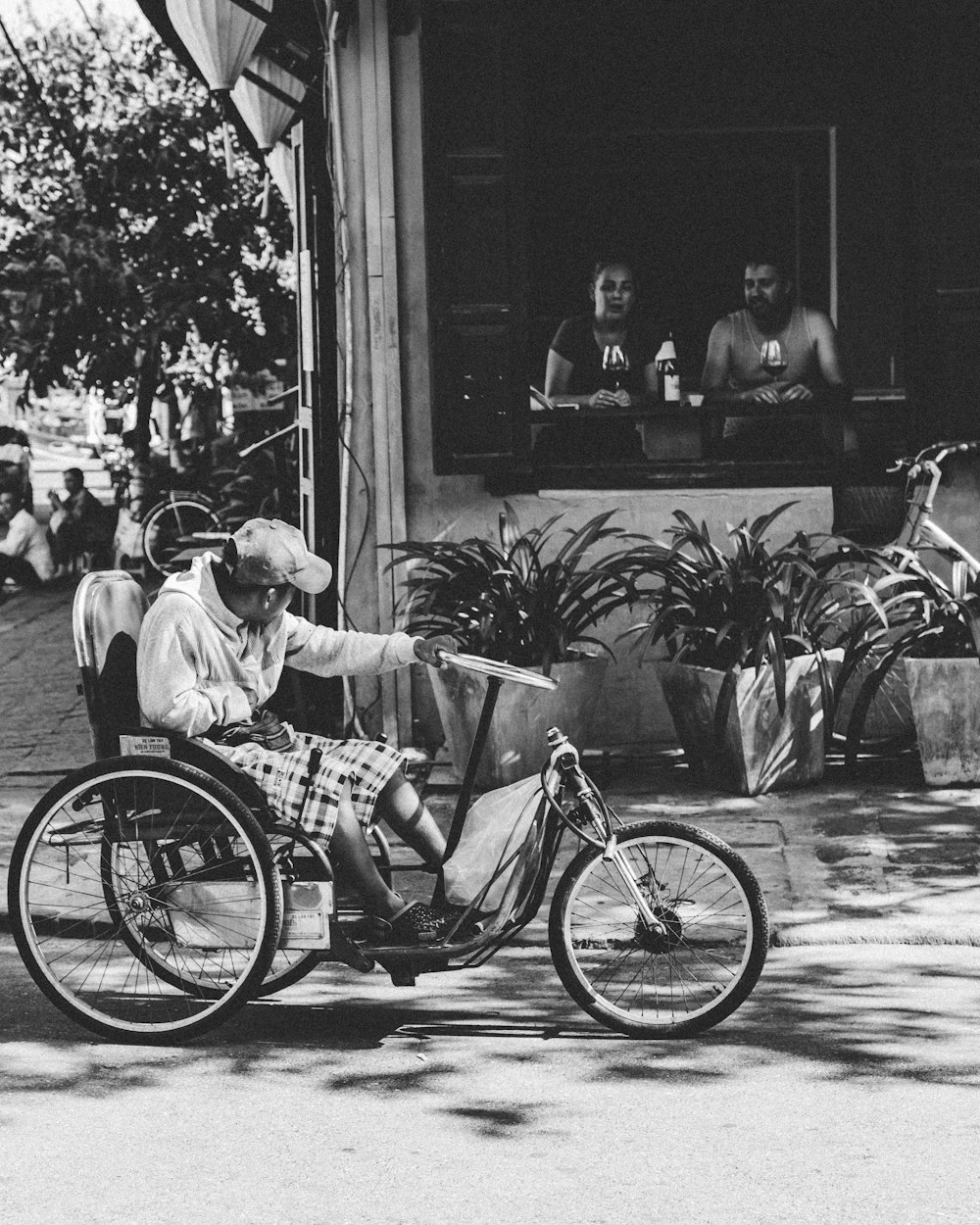 grayscale photography of man on trike