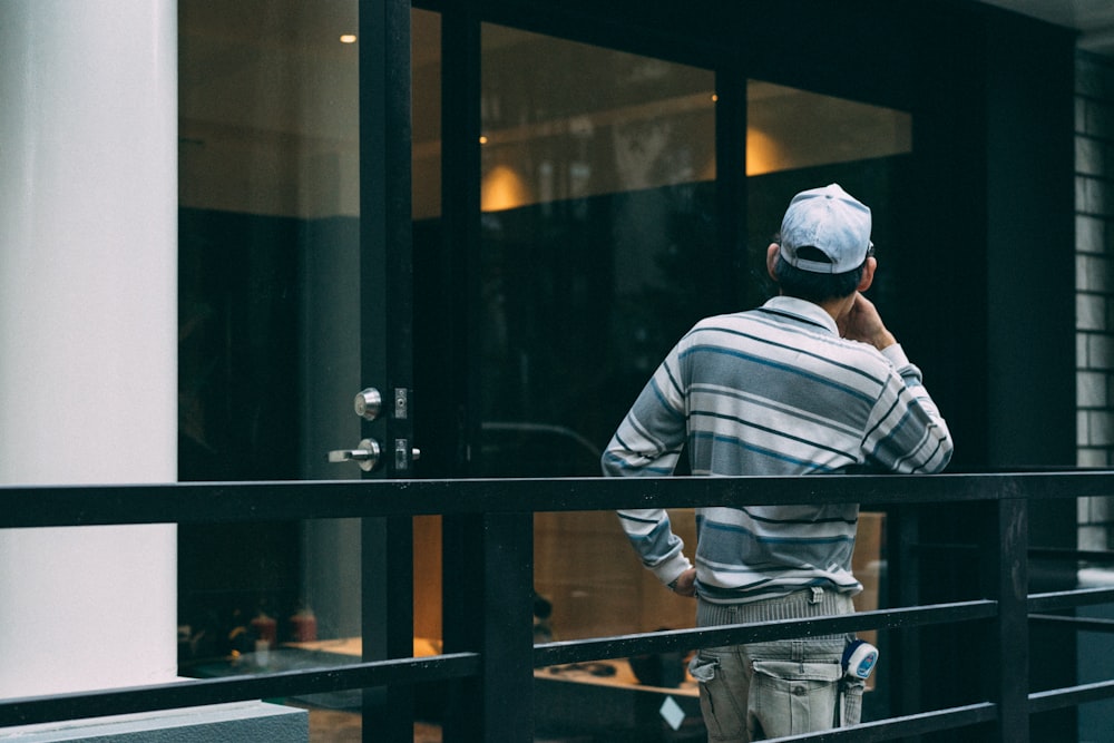 man leaning on black metal railing