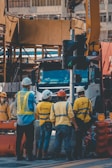 A group of workers wearing safety helmets and vests.