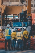 Photo of a diverse group in a safety training session wearing helmets and reflective vests