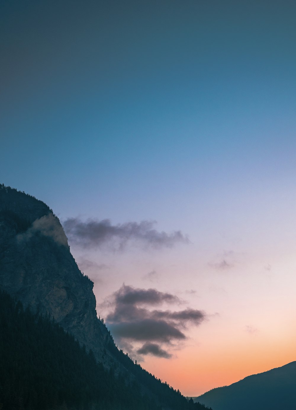 a mountain with a few clouds in the sky