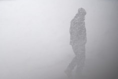 silhouette of man in snow storm