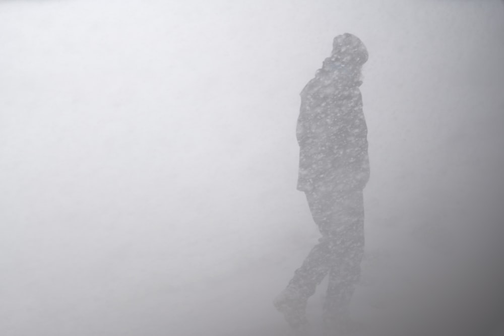 silhouette of man in snow storm