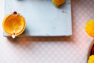 A detailed kundali chart glowing softly against a dark yellow background with subtle Rudraksha beads framing the edges.