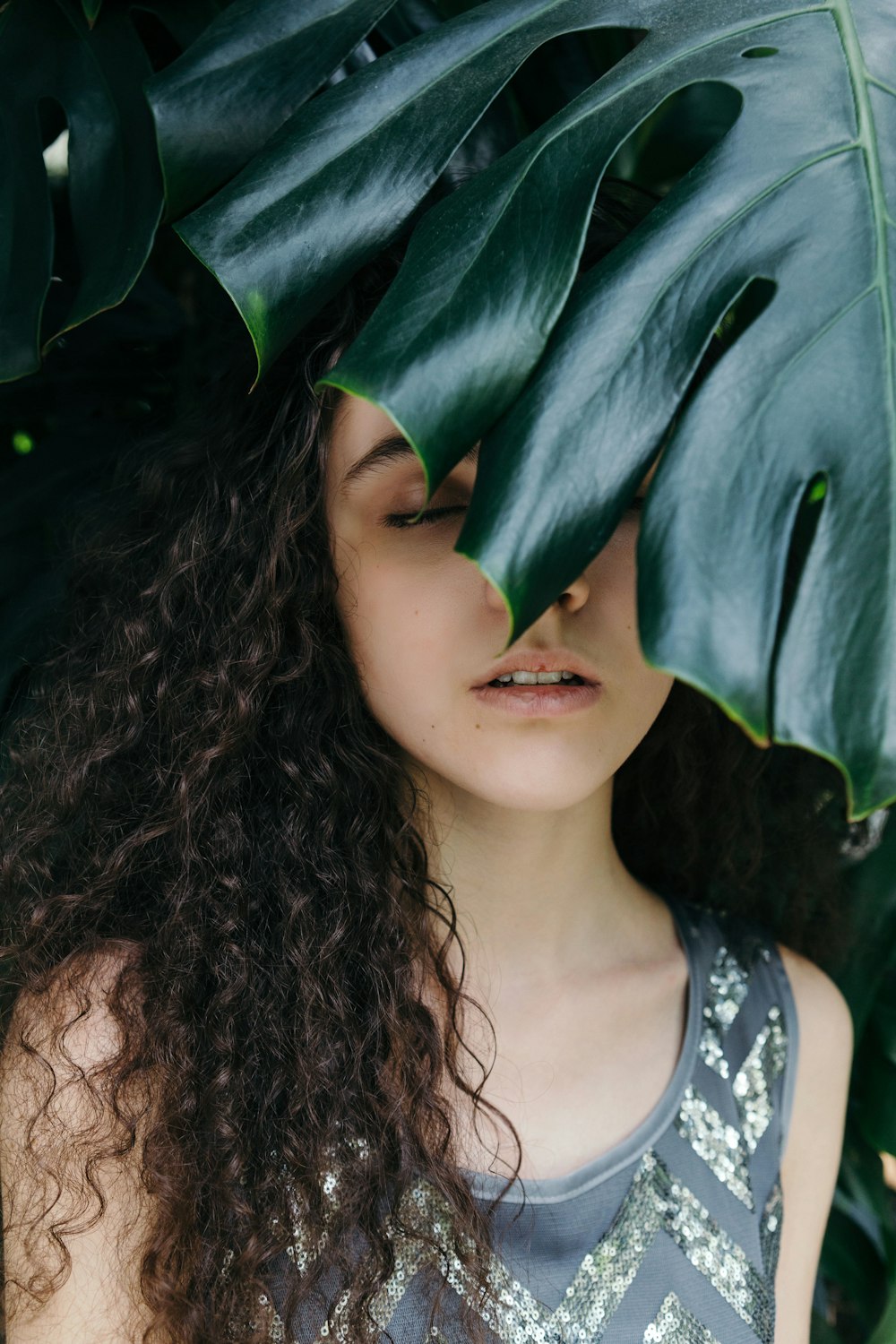 woman wearing black tank top beside green-leafed plant