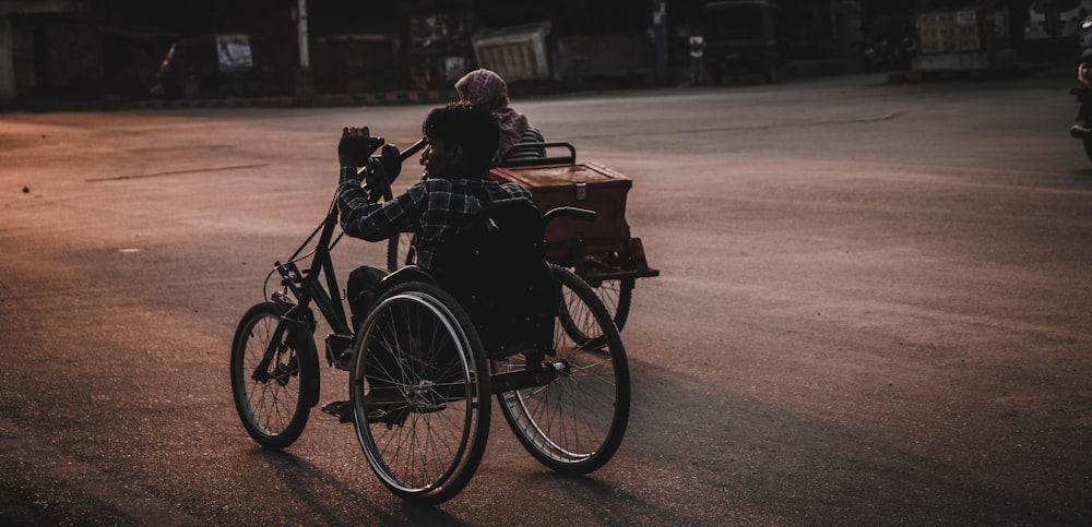 two persons riding trikes on road