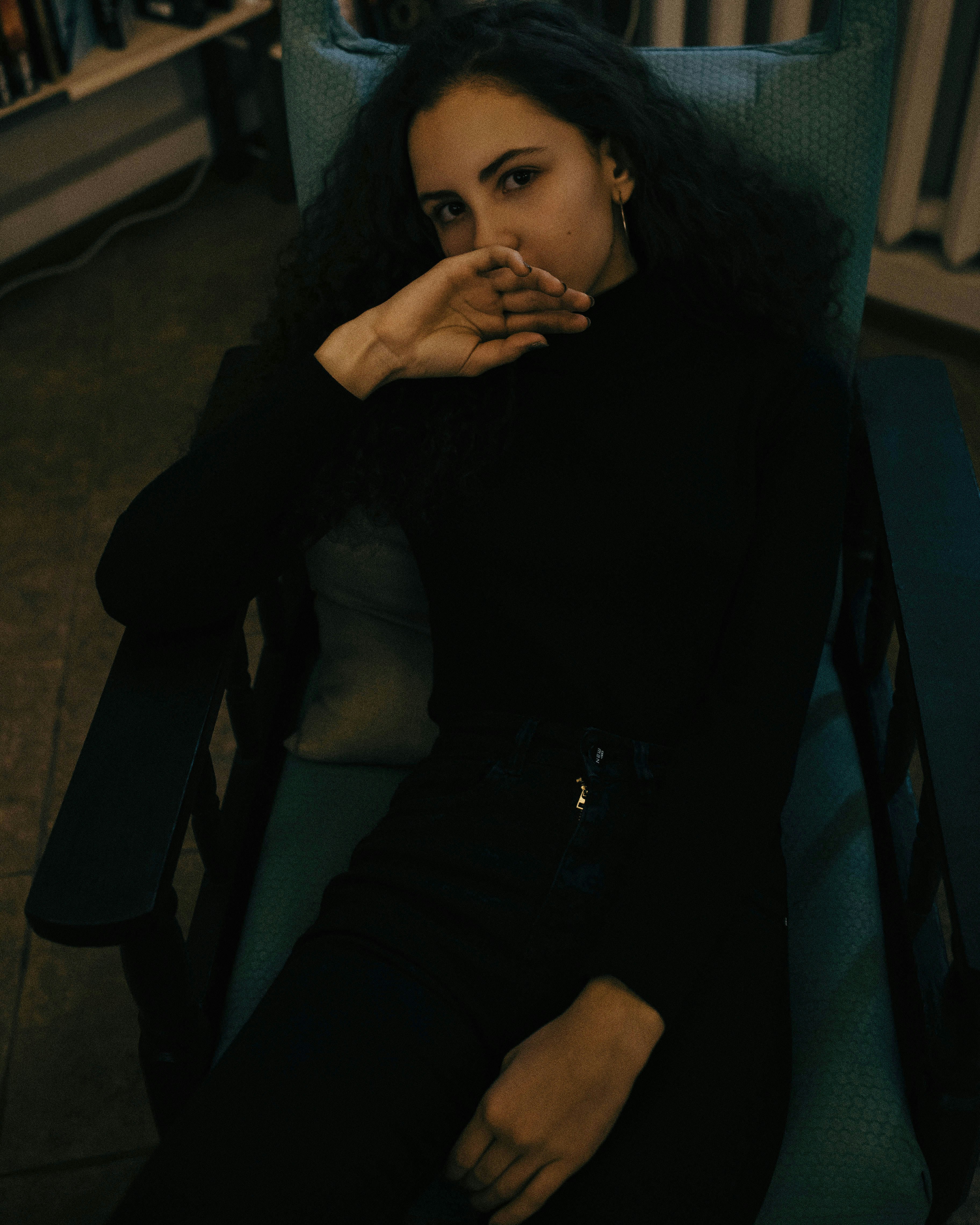woman in black long sleeved shirt sitting on armchair