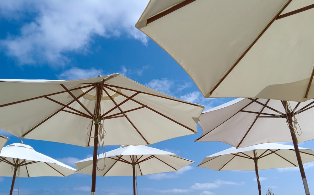 white parasols under blue and white clouds