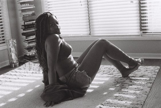 Portrait of Tao Yachaï sitting in a cozy room surrounded by books and a notebook.