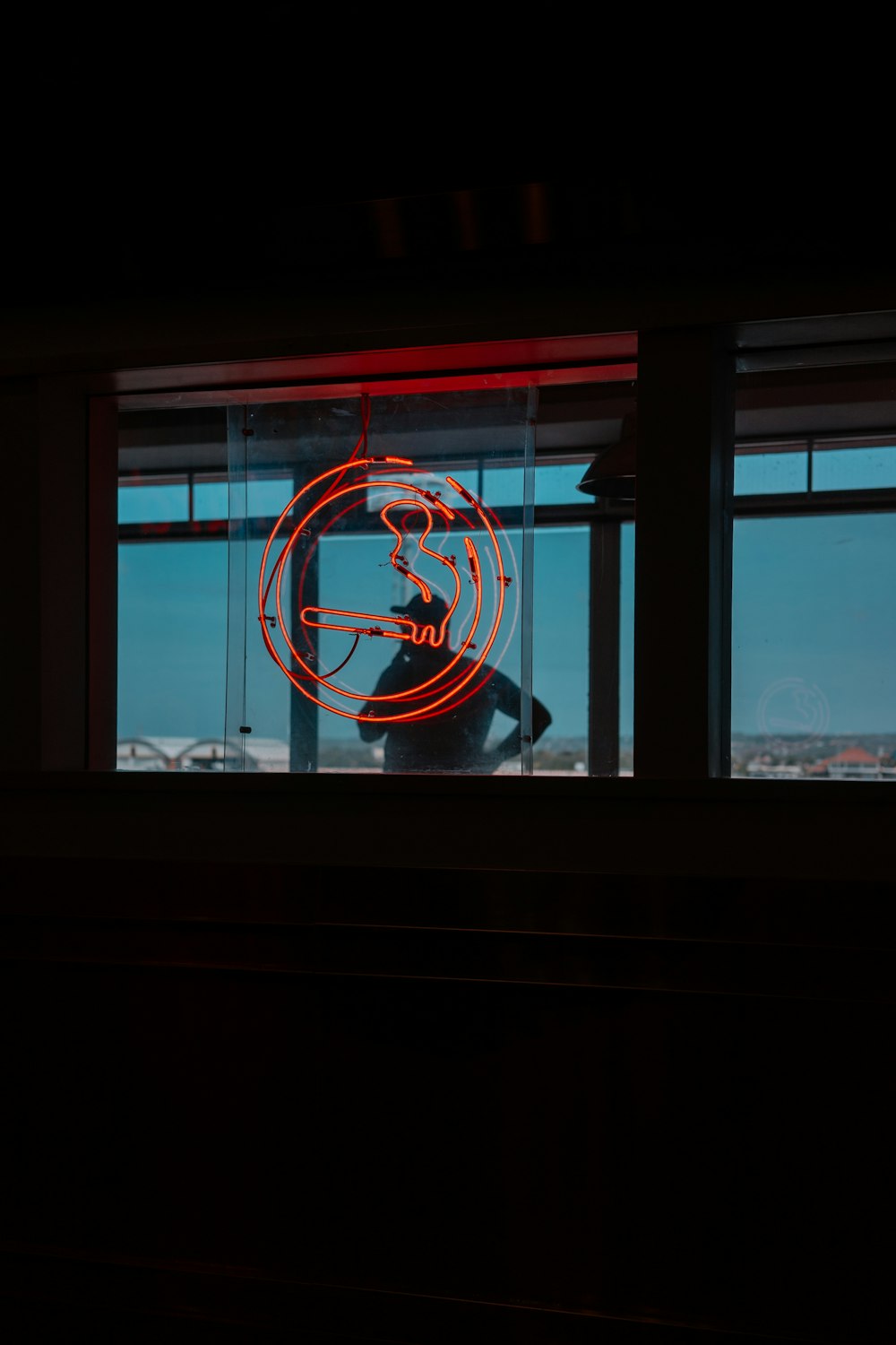 Un'insegna al neon davanti a una finestra in una stanza buia