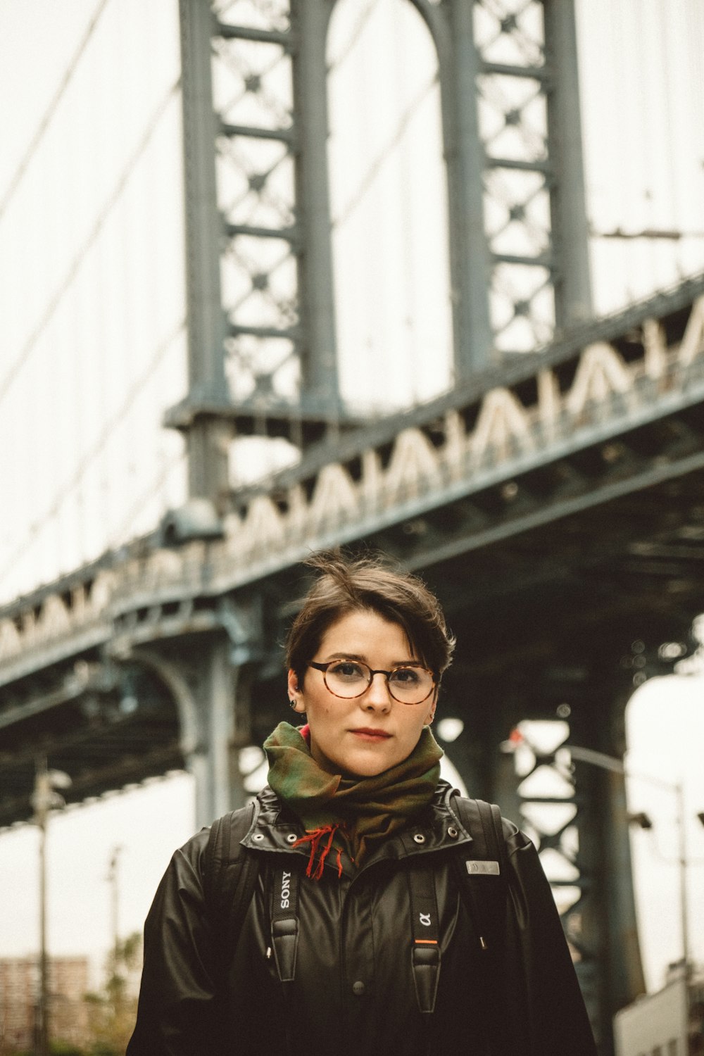 selective focus photography of woman standing in front of beam bridge