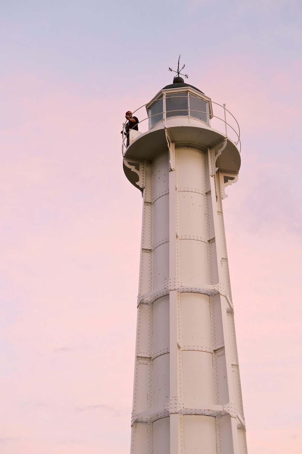 man standing on white lighthouse