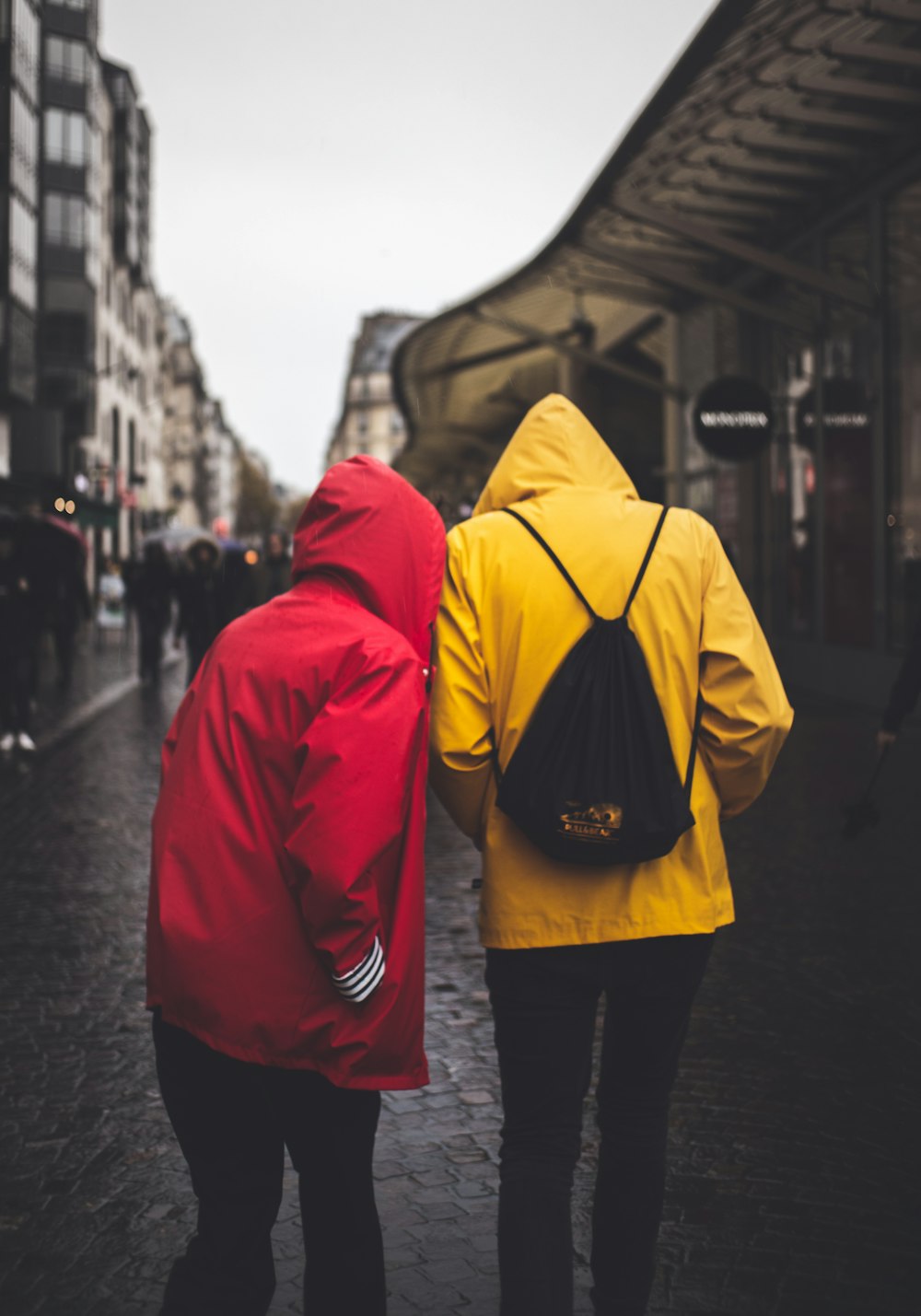two people in yellow and red hoodies in middle of road