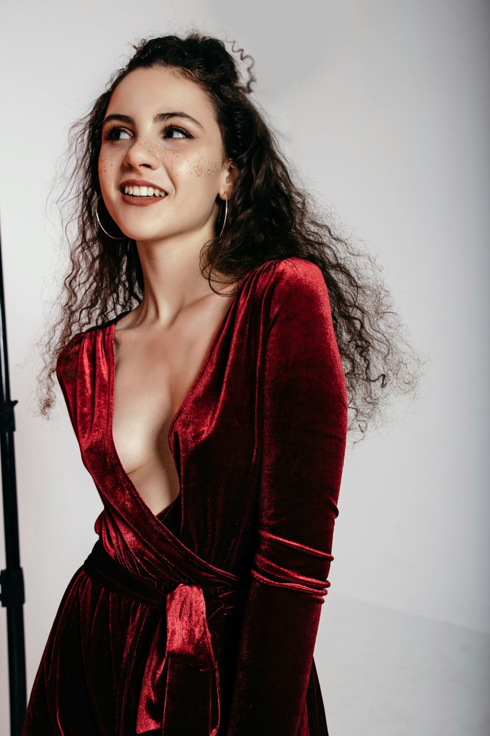 woman wearing red surplice long-sleeved dress standing inside room