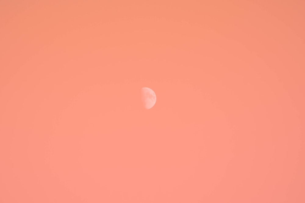 Un aereo che vola nel cielo con la luna sullo sfondo