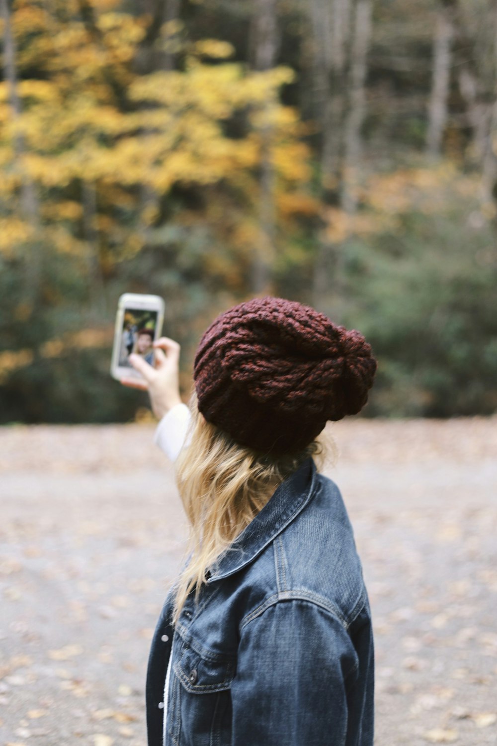 mujer tomando selfie cerca de los árboles