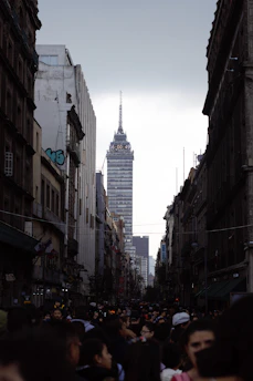 A crowded Chicago street lined with tall buildings, busy with people and cars under a gray sky.