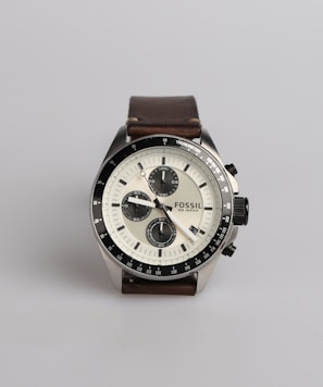 round silver-colored Fossil chronograph watch at 9:22 with brown leather band