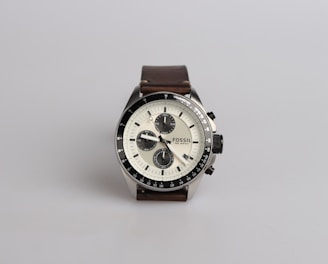 round silver-colored Fossil chronograph watch at 9:22 with brown leather band