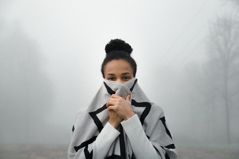 Frau bedeckt ihr Gesicht mit Nebel