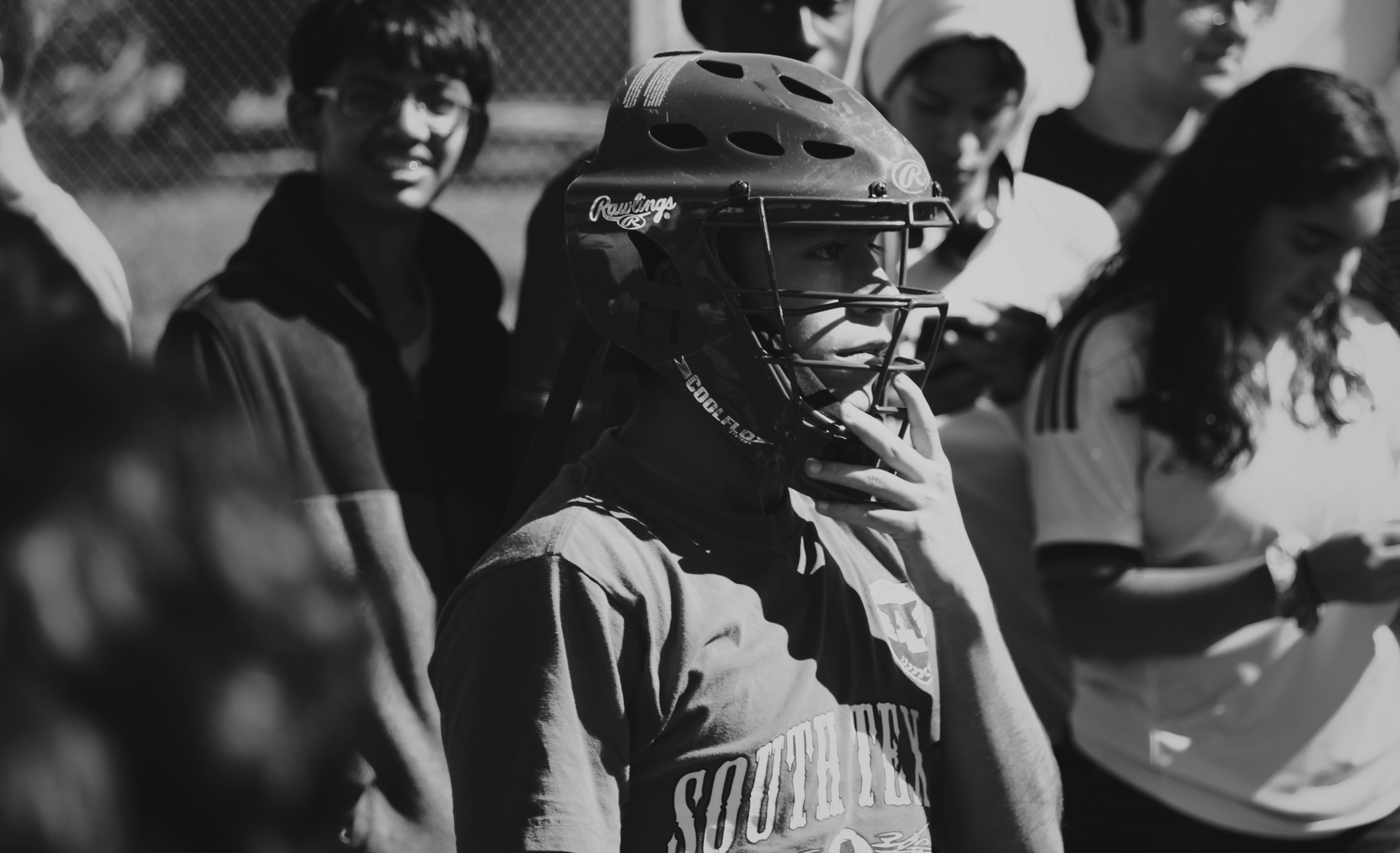 grayscale photo of man wearing catchers helmet