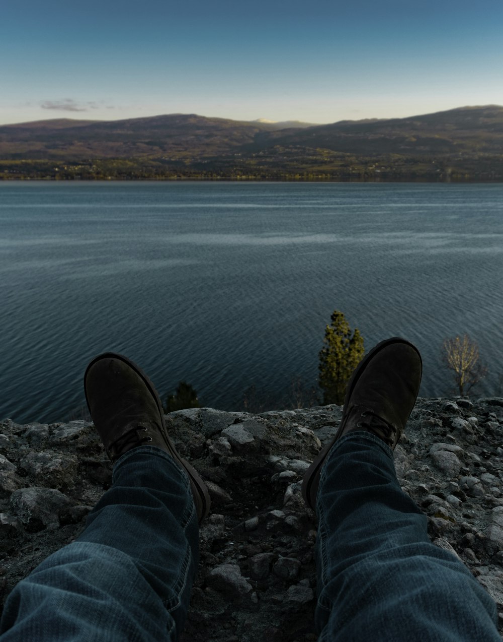 person lying on gray rock