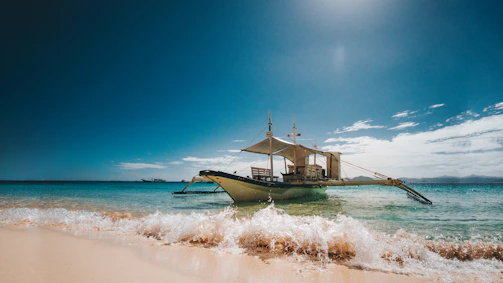 Crystal-clear turquoise lagoon with a traditional Maldivian dhoni boat anchored nearby.