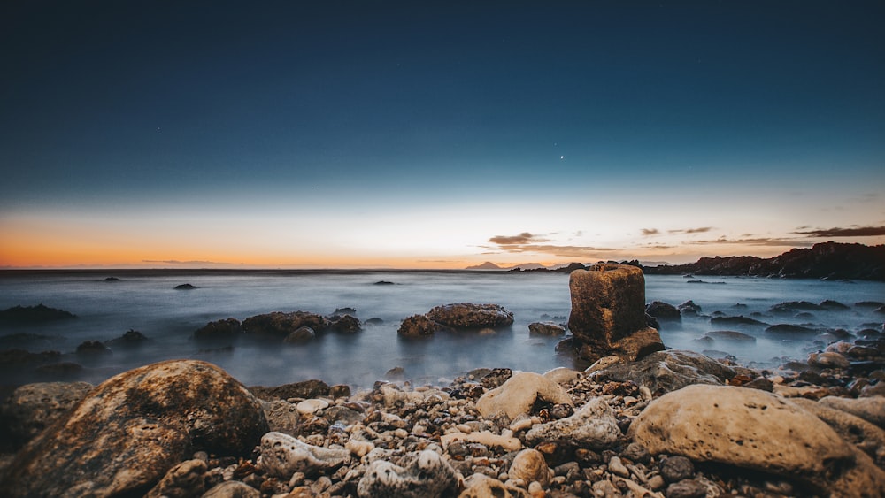 assorted-color rocks beside sea