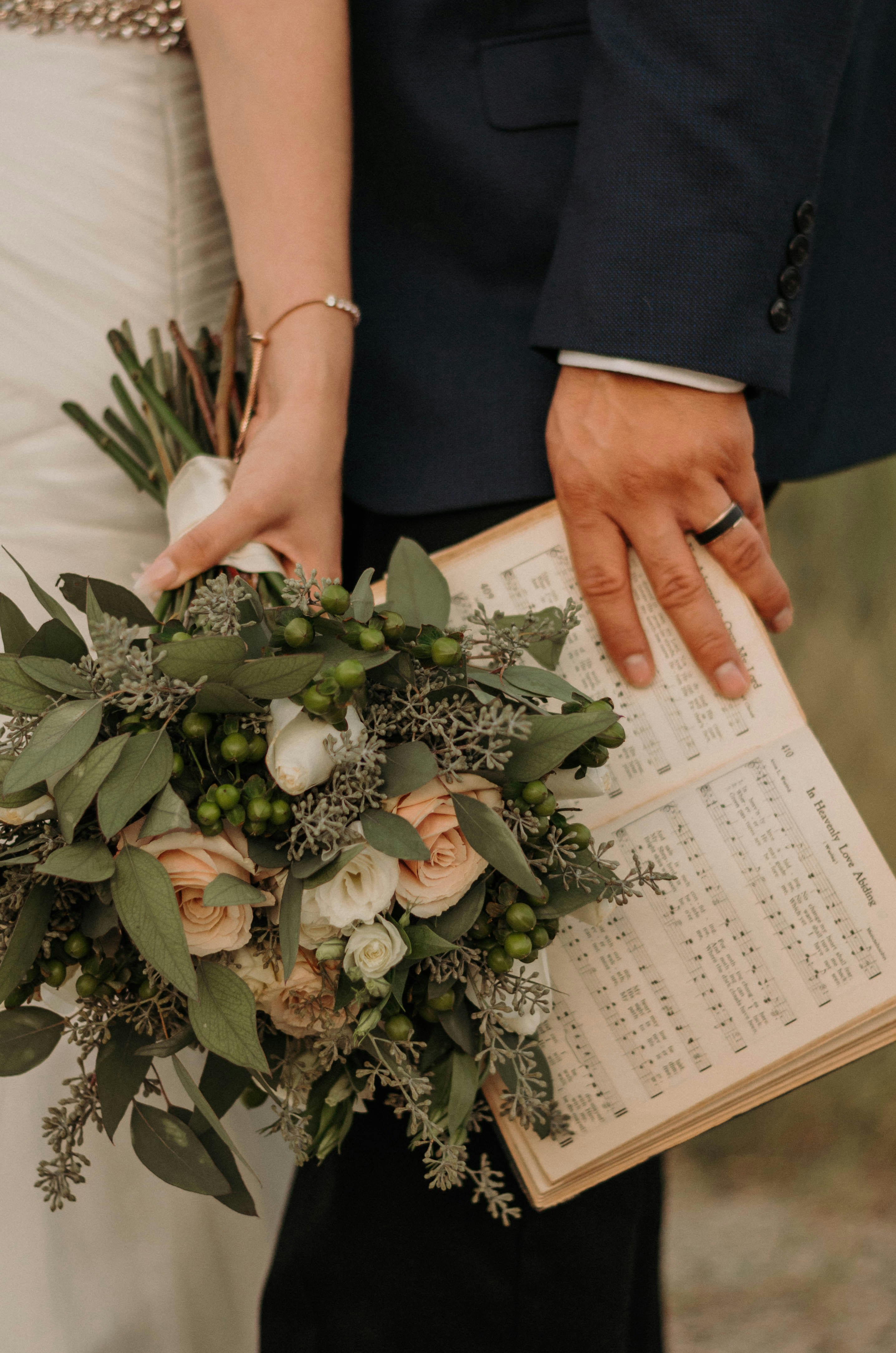 Wedding rings flowers, Wedding planner notebook, Couple holding hands, ilustrasi artikel Stress-Free Wedding Budgeting: Your Ultimate Guide to a Joyful Day 7
