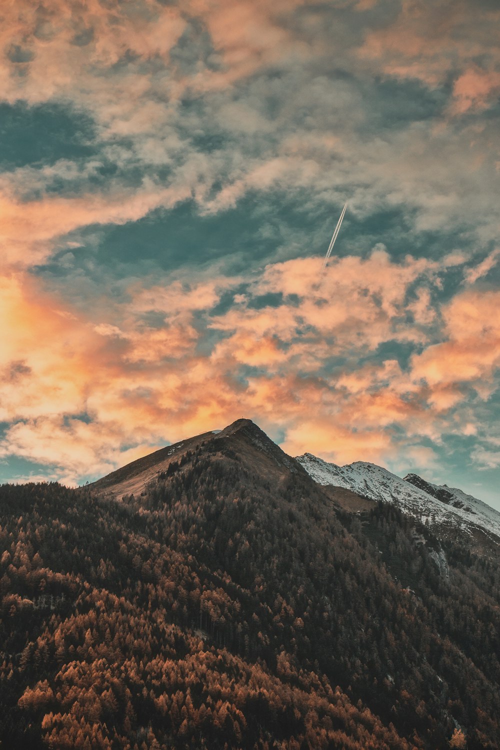 mountain top under grey and orange clouds