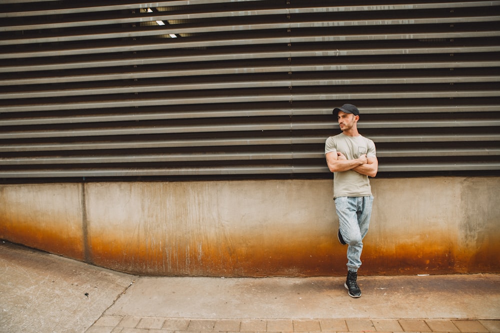 man leaning on wall during daytime