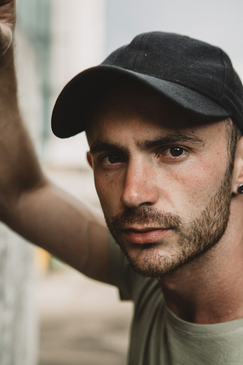 man in grey t-shirt wearing black cap