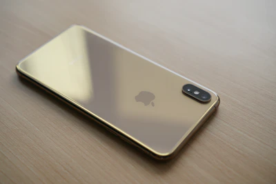 A sleek smartphone displaying the bink app interface with gold and off-white accents.
