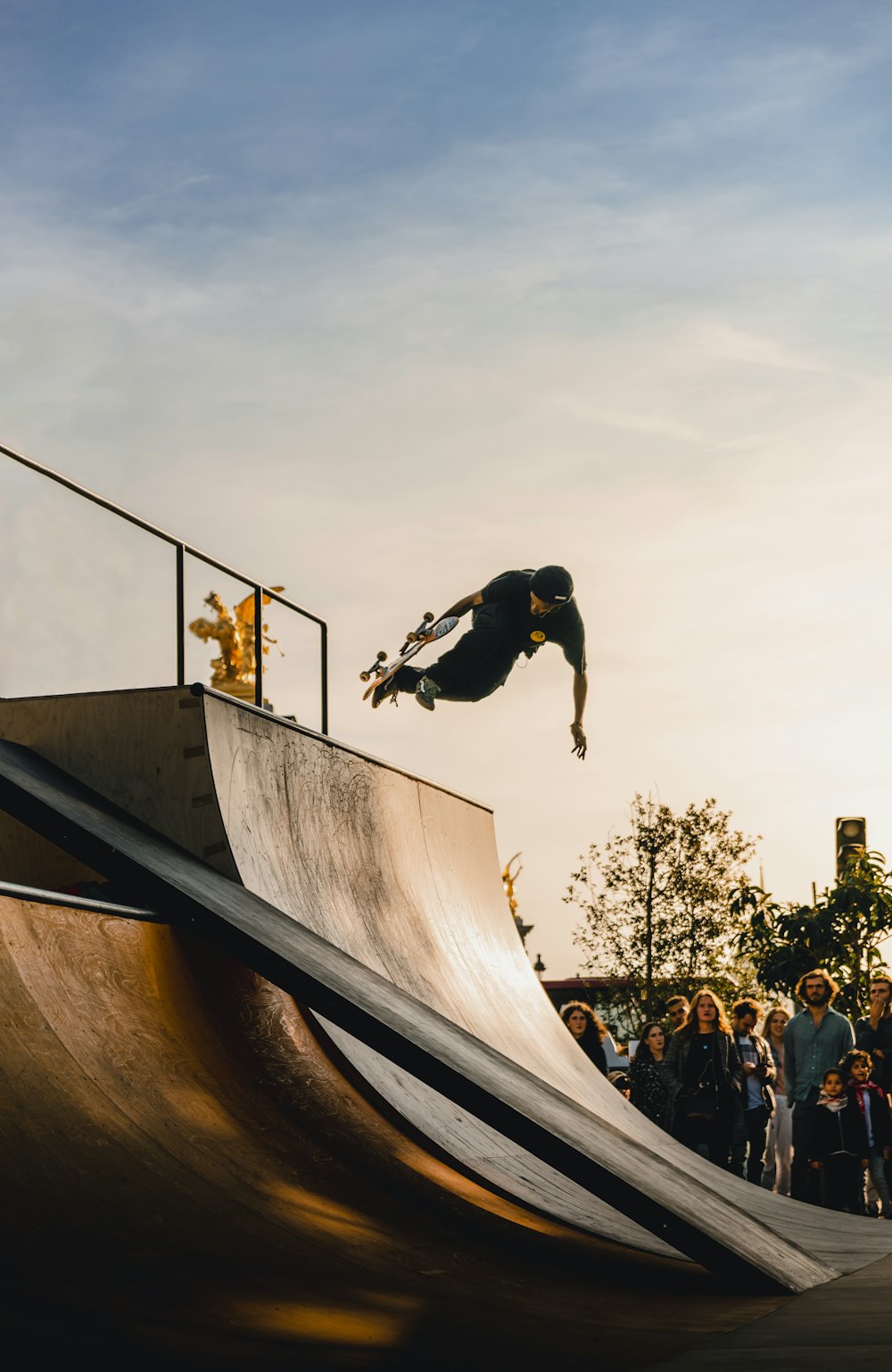 les gens regardent l’homme faire du skateboard à la rampe