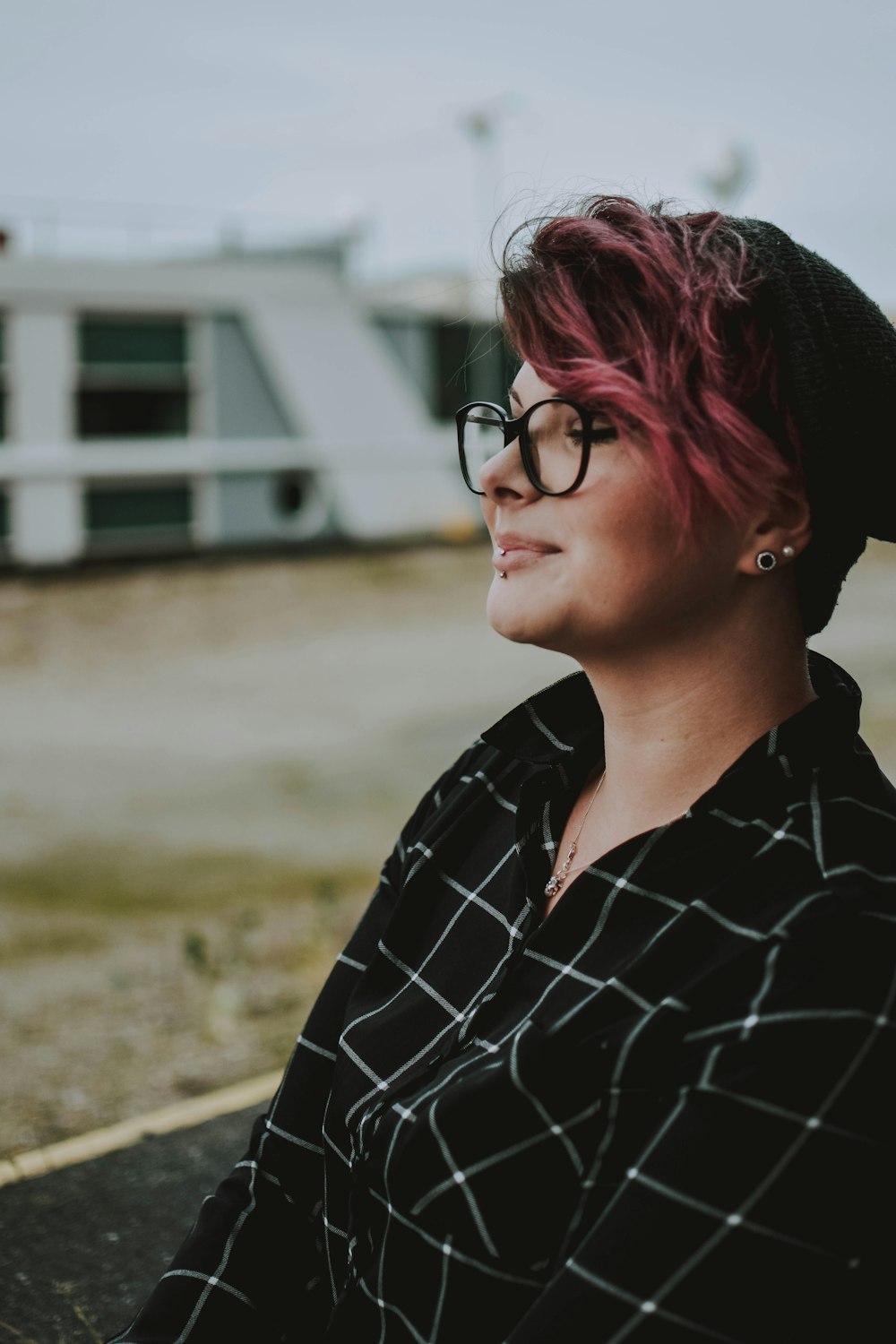 woman wearing black framed eyeglasses and black and white plaid top during daytime